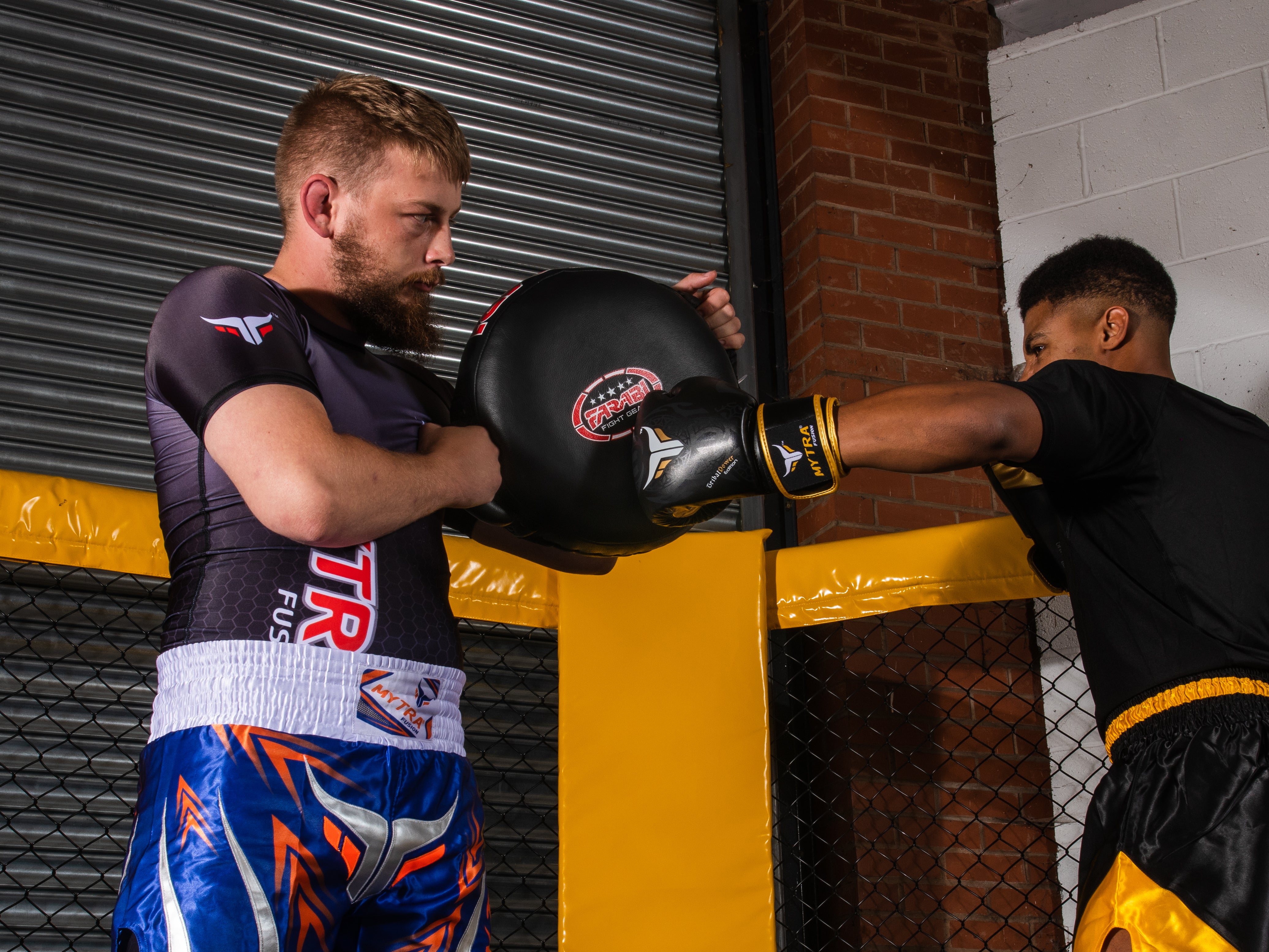 Farabi Sports boxing training session featuring a fighter practicing punches with focus mitts.