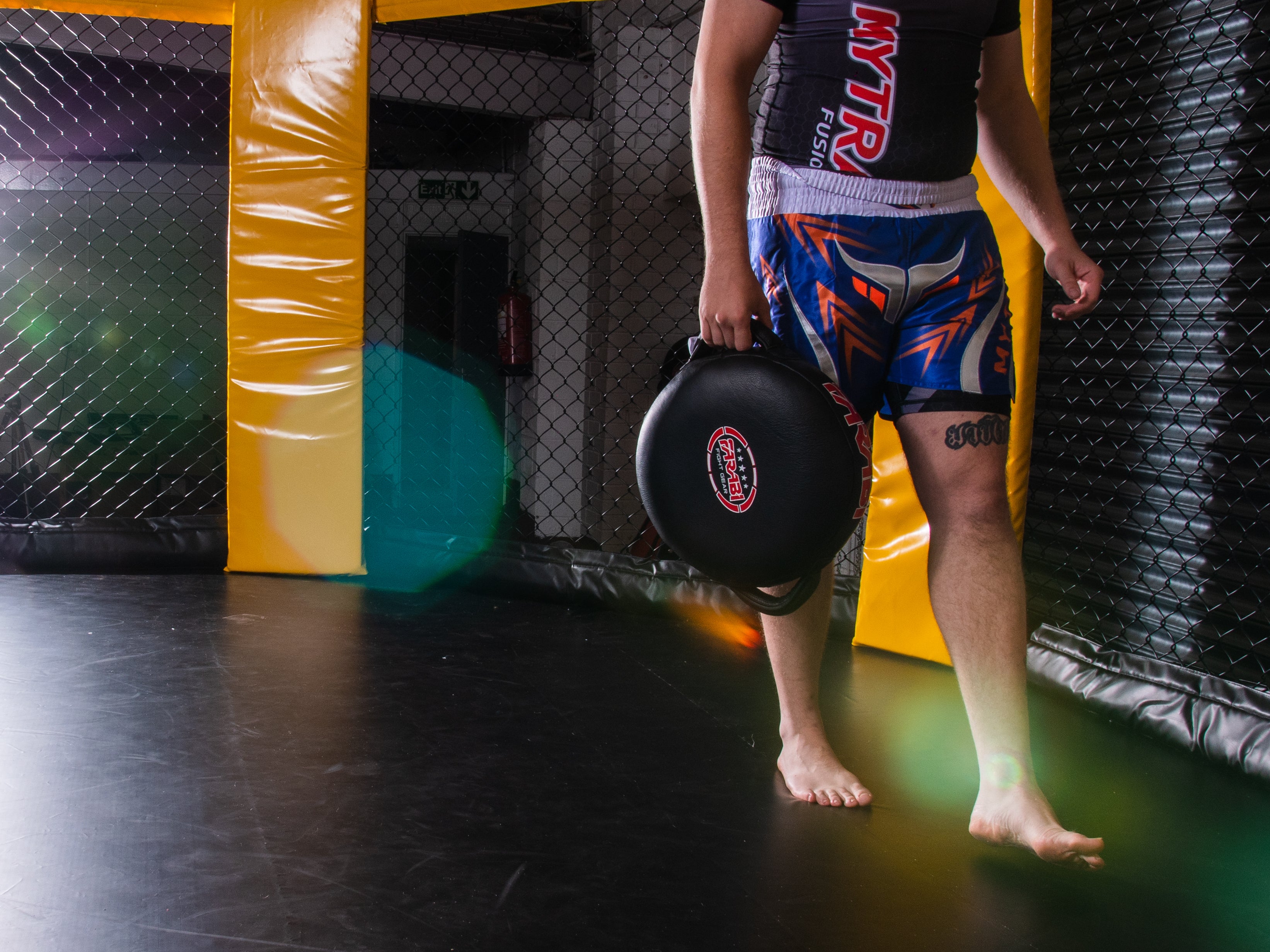 Farabi Sports MMA fighter holding a focus mitt, ready for training in the gym.